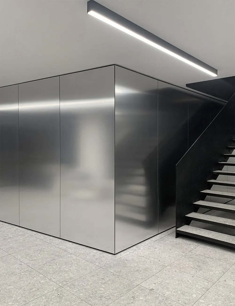 Contemporary office interior at VAL Industries featuring Abet Laminati's Metalli 873 in Satinata finish on walls and architectural volumes.