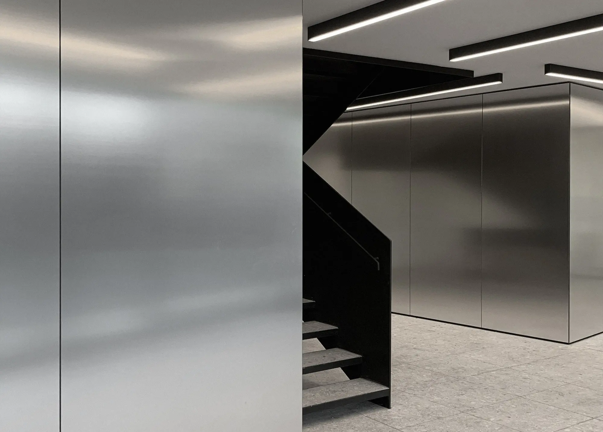 Contemporary office interior at VAL Industries featuring Abet Laminati's Metalli 873 in Satinata finish on walls and architectural volumes.