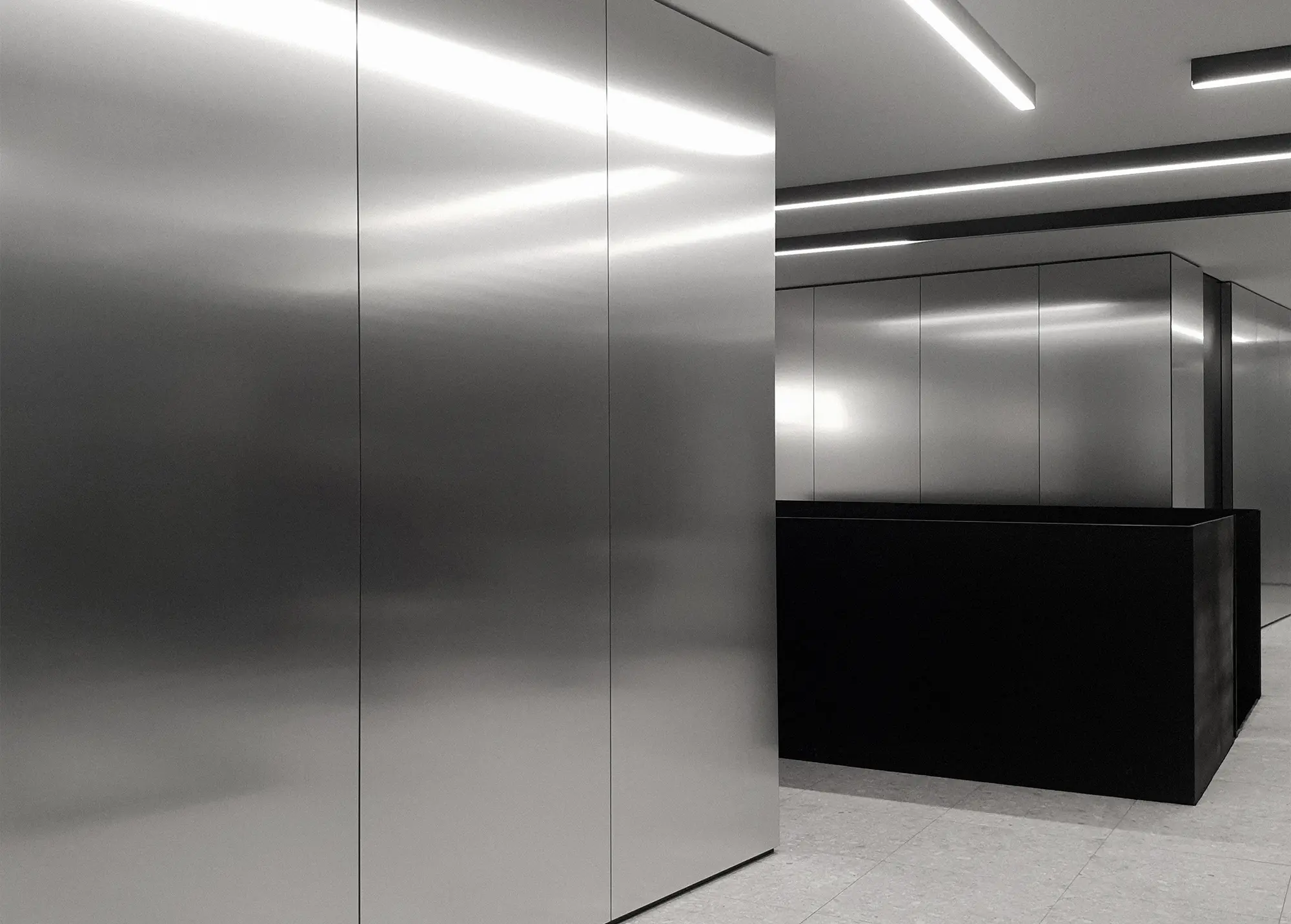 Contemporary office interior at VAL Industries featuring Abet Laminati's Metalli 873 in Satinata finish on walls and architectural volumes.