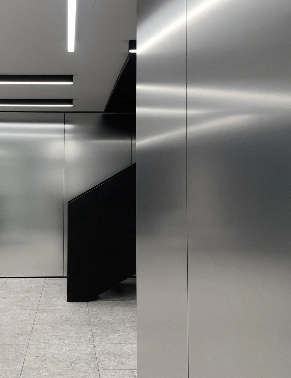 Contemporary office interior at VAL Industries featuring Abet Laminati's Metalli 873 in Satinata finish on walls and architectural volumes.